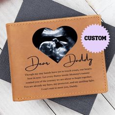 a leather coaster with a photo of a baby's feet and the words dear daddy printed on it