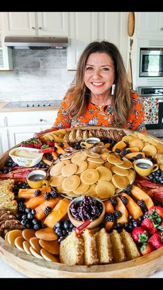 a woman sitting in front of a large platter of food