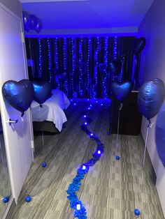 blue balloons and streamers are on the floor in a bedroom decorated for valentine's day