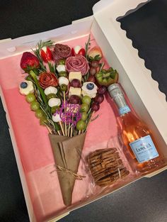 a bottle of wine and some flowers in a box