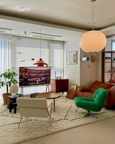 a living room filled with furniture and a flat screen tv mounted to the side of a wall