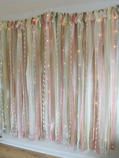 the curtain is decorated with pink and white ribbons on it's sides, along with lights