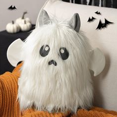 a white stuffed animal sitting on top of a couch