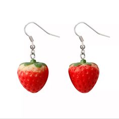 a pair of earrings with a strawberry hanging from it's earwires on a white background