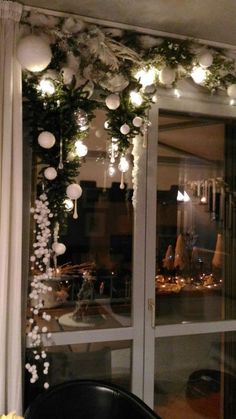 the window is decorated with white ornaments and greenery for an elegant touch to the room