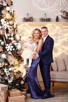 a man and woman standing next to a christmas tree