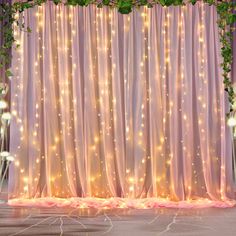 the backdrop is covered with lights and greenery