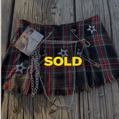 a tartan kilt with chains and stars on it, sitting on a wooden floor