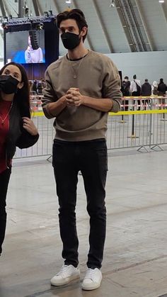 a man and woman wearing face masks in an indoor arena