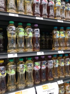 many bottles of liquid are on display in a store