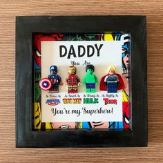 there are some legos in a frame with the words daddy on it and captain america