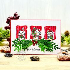 a christmas card with donuts and pine cones on a table next to evergreen branches