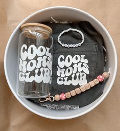 a couple of cups sitting inside of a white bowl next to a black bag on top of a table