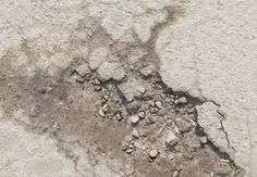 the cement is white and has cracks in it's surface, as well as small rocks