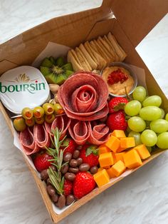 a box filled with assorted fruits and cheeses on top of a white counter