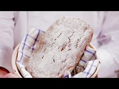 a person holding a bowl with some food in it and a napkin on the other side