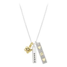 a silver and gold necklace with two hearts on it, one has a flower in the middle