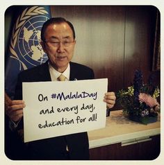 a man holding up a sign that says on malaysia and every day education for all