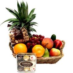 a basket filled with fruit and nuts next to a container of chocolates