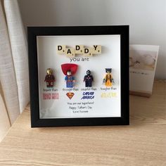 there is a framed picture with some legos on it and the words daddy you are spelled in scrabble