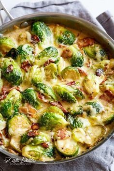 a pot filled with broccoli and cheese on top of a table