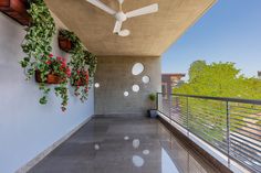 a balcony with potted plants and ceiling fans