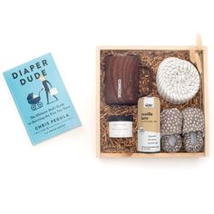 the diaper dude gift box includes baby shoes, socks, and other personal care items