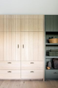 a large wooden closet with many drawers and baskets on it's shelves in a room