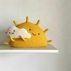 two stuffed animals sitting on top of a shelf next to each other in front of a white wall