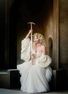 a woman in white dress holding an umbrella