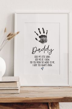 a white framed print with the words daddy and handprints in black on it