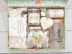 an open gift box filled with personal care items on top of a white wooden table