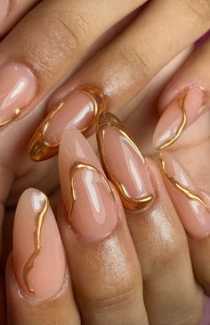 Celebrate graduation with elegant nude and gold almond nails. Ideal for adding a touch of glamour and sophistication to your look. Save this pin for graduation nail ideas! #GraduationNails #NudeNails #GoldNails #AlmondNails #NailInspo Abstract Gold Chrome Nails, Gold Accent Nails Almond, Clean Elegant Nails, Almond Gold Nails Designs, Molten Gold Nails, Gold Beige Nails, Gold Squiggle Nails, Gold And Nude Nail Designs, Gold Nail Gems