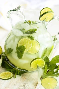 a pitcher filled with lemonade and lime slices