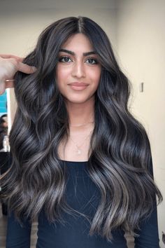 This enthralling hairstyle flaunts a luxurious waterfall of black waves, artfully accentuated with delicate ash-toned highlights that forge a smoky contrast. The subtle, cool-hued streaks are skillfully woven throughout the deep ebony tresses, lending depth and dimension to the flowing locks. This style is ideal - Click to see more of Effortlessly Elegant: 20 Smoky Ash-Highlighted Styles to Elevate Black Hair and follow us for more hairstyle ideas. // Photo Credit: Instagram @michaelhairlondon Dark Hair Ash Brown Highlights, Black And Ashy Hair, Dark Hair With Ash Blonde Balayage, Dark Hair Balayage Ideas, Subtle Dimension Dark Hair, Brunette With Ash Brown Highlights, Black Hair Balayage Cool Tone, Smoky Dark Brown Hair