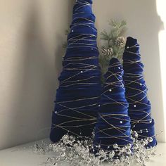 three blue christmas trees are sitting next to each other