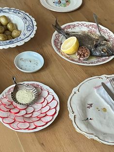 several plates with food on them sitting on a table next to utensils and spoons