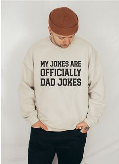 a man wearing a sweater that says, my jokes are officially dad jokes