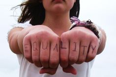 a woman holding her hands with the word equality written on them