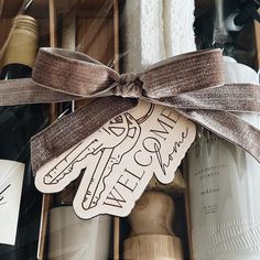 a bottle of wine with a ribbon tied around it and some bottles in the background