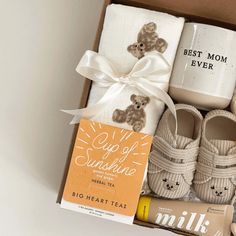 the baby gift box is packed with shoes, socks, and coffee mugs for mom