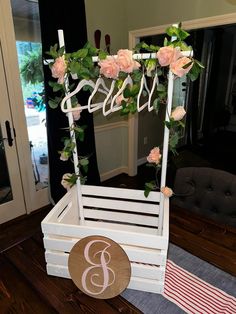 a white wooden crate with flowers and a monogrammed sign on it that says bride