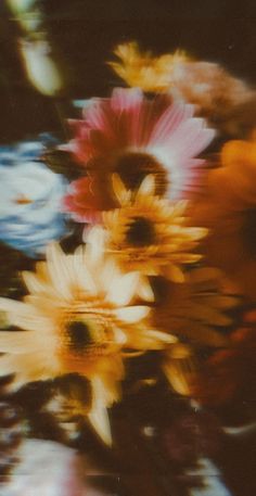 blurry photograph of colorful flowers in a vase