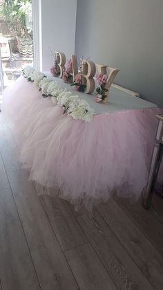 the table is decorated with pink tulle and flowers for a baby's first birthday