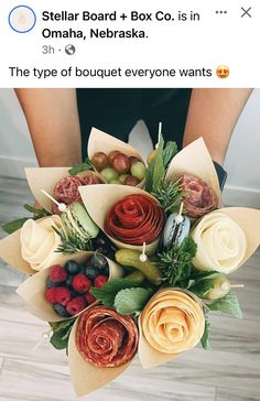 a woman holding a bunch of flowers on top of a wooden floor