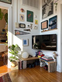 a living room with pictures on the wall and a television mounted to the wall above it