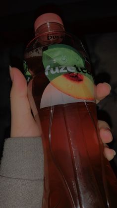 a person holding a bottle of juice in their hand