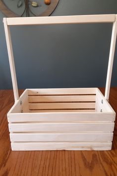 a wooden crate sitting on top of a wooden table next to a wall mounted clock