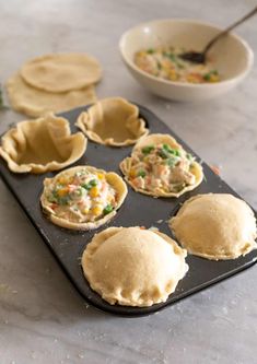 small pies are lined up on a baking tray