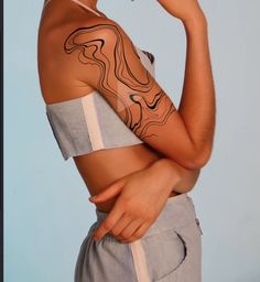 a woman with tattoos on her arm and shoulder